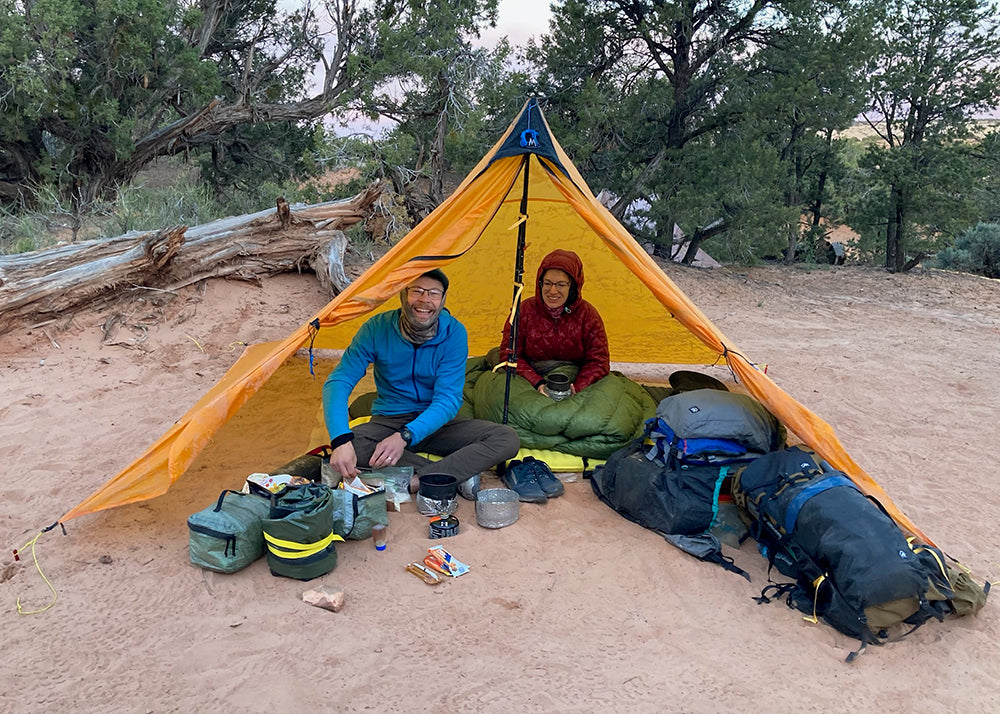 SWD founders under an ultralight tarp shelter with their gear