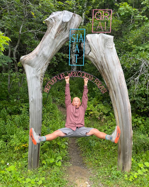 lil buddha hangs from a sign in the woods