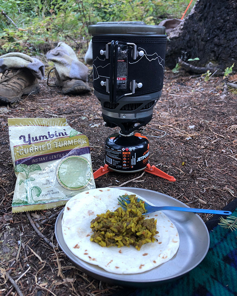 yumbini on a tortilla outside with a camping stove in the background