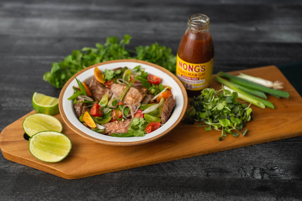 Nong's Thai beef salad with extra garnish and sauce on the side.