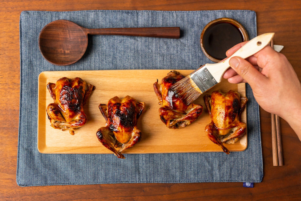 Glazing the quails with Nong's sauce reduction.