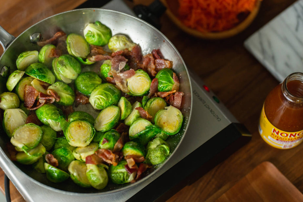 Brussels sprouts and bacon cooking in the pan.