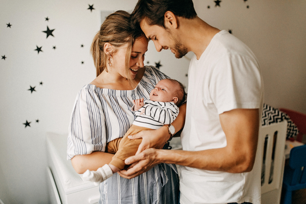 Parents holding little baby and both looking at the baby