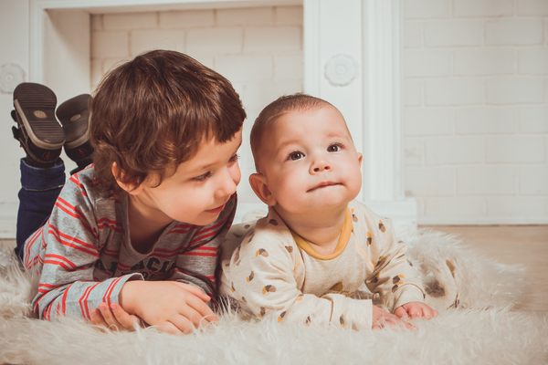 Toddler and baby lying on their stomachs