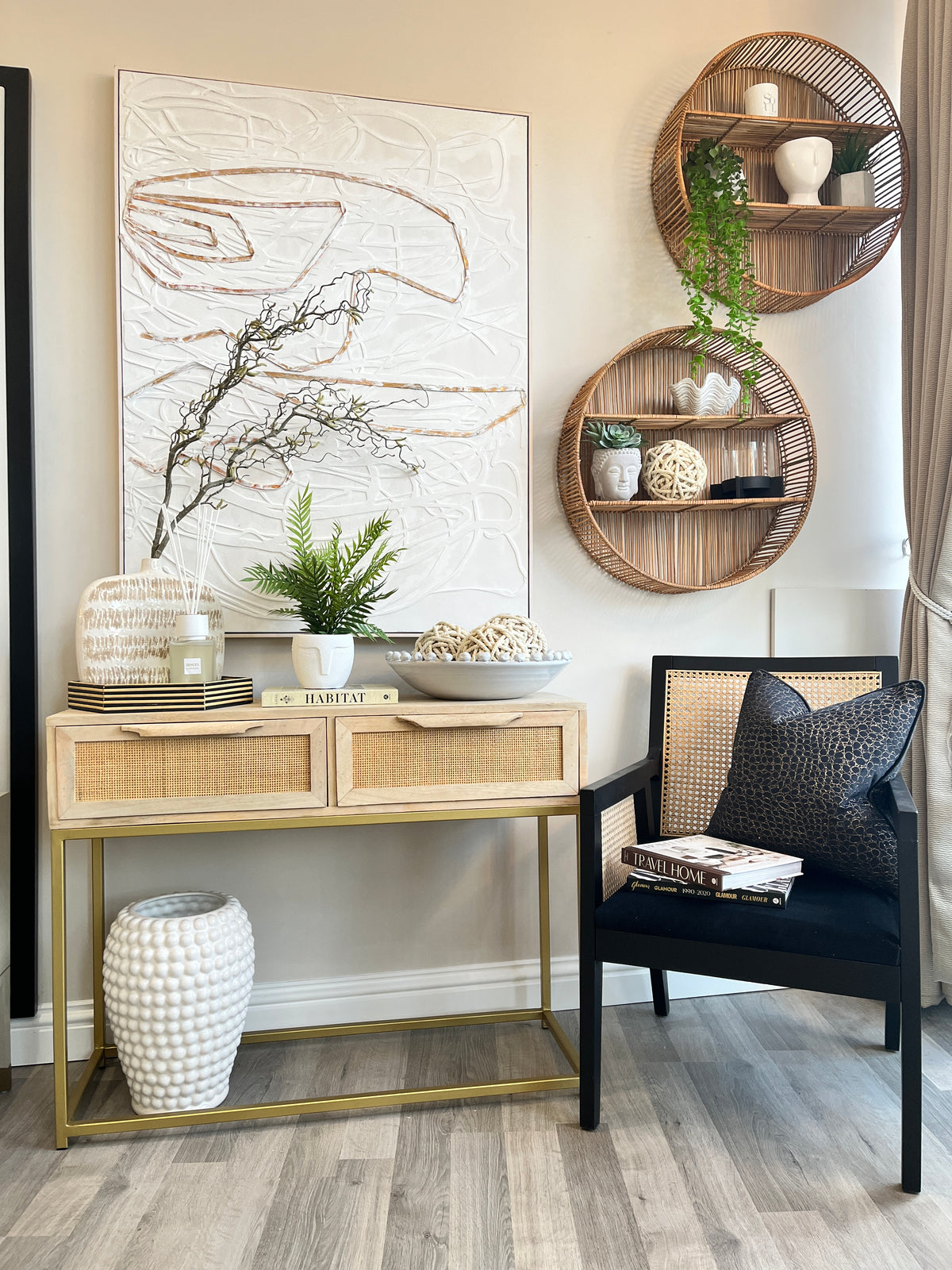 Wooden sideboard styled with ceramic accessories, silk flowers, glass table lamp and an arched window wall mirror 