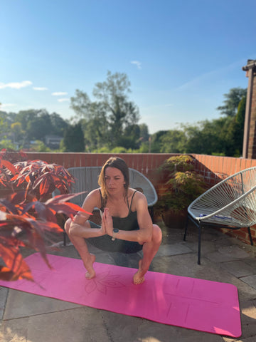 Yogi in goddess pose on a pink Meliora mat