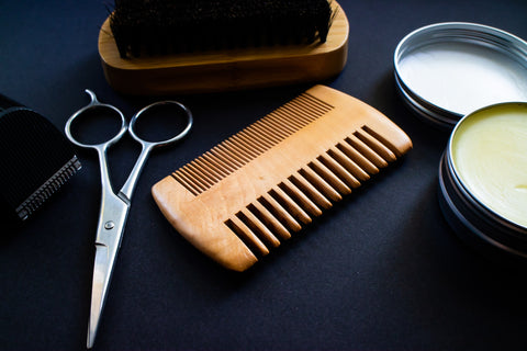 beard comb shears beard brush beard balm on table
