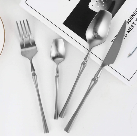 Kitchen Cutlery | Silver fork, spoon and knife next to each other on a white table. 