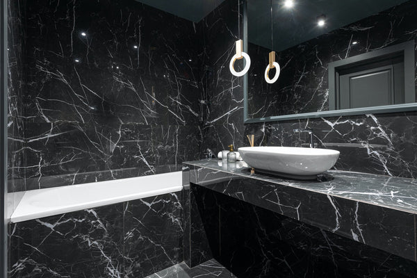 bathroom with black marble walls, tub and sink