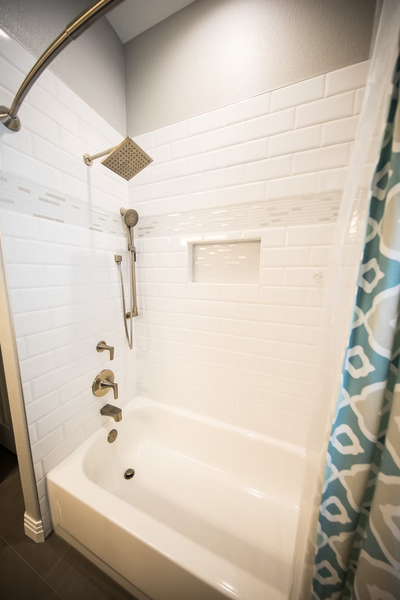white bathroom and tub with matching shower fixtures and tub spout