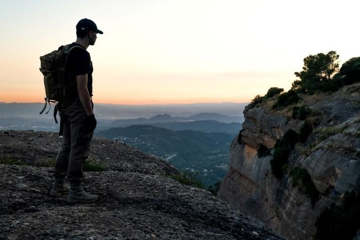 Man wearing tactical clothing standing on a cliff