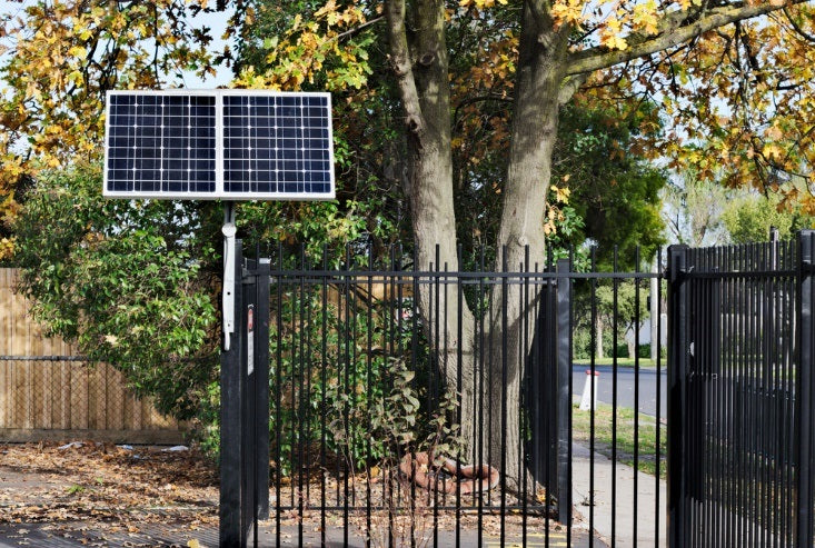 Solar panel installed on top of black stainless gate