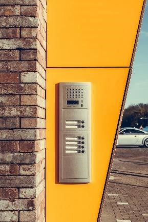 Wireless intercom system installed in yellow outdoor wall