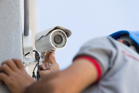 cctv technician working on camera outdoor during day time