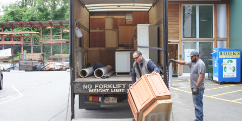 Two men loading a kitchen cabinet into a truck