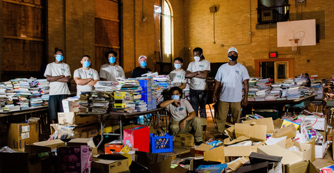 A group of people in masks stands in front of materials about to be donated to EcoBuilding Bargains. 