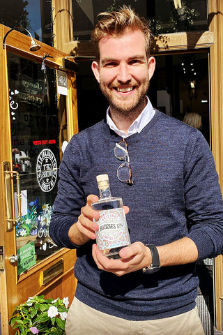 Photo of David Montgomery, Buddies Gin Director holding a bottle of Buddies Gin outside the office on Paisley High Street