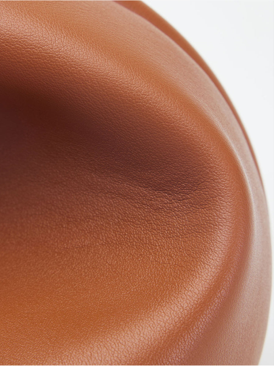 Close-up of rich, cognac-brown leather, showcasing its smooth texture and luxurious quality – perfect for a sophisticated and durable handbag