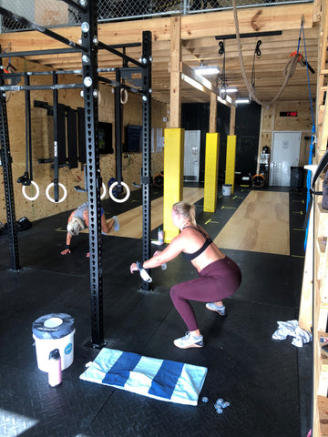 A SoWal CrossFit® athlete performing an air squat by the Rogue® Fitness monster rig