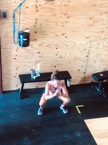 A SoWal CrossFit® athlete performing a body weight movement called an air squat. This is a typical movement found in The Burn programming.