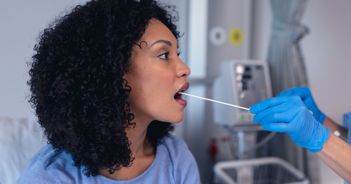 Woman with swab in mouth for strep throat test