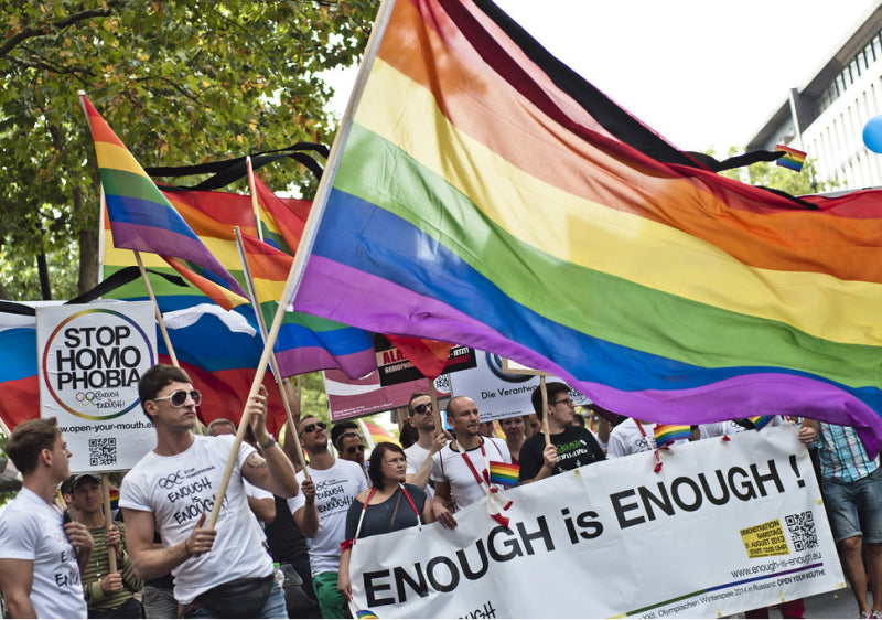 OutRAGE LGBTQ+ Advocacy Group Pride March with protesters holder slogan signs and pride flags