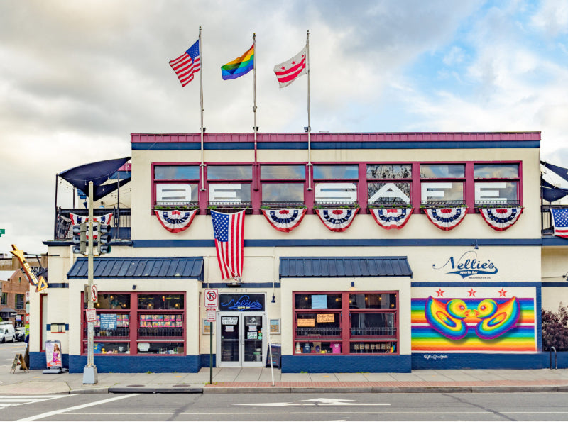 White restaurant called “Nellies” decorated with American flags and rainbow pride flags