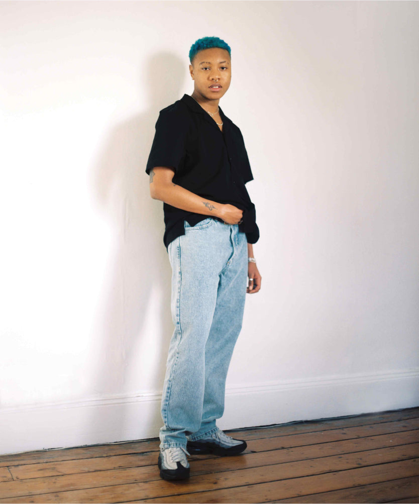 Model with black button down shirt and light blue denim Jo jeans