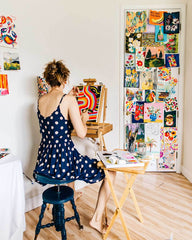 Artist at her easel painting original fine art painting in her art studio