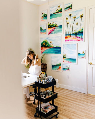 Artist Jordan McDowell at Desk in Studio with Framed Art on Wall