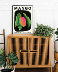 Mango art print poster with plants sitting on a cabinet 