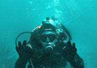 a diver showing ok sign while deep underwater