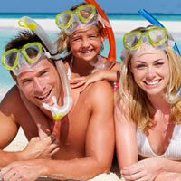 family with masks and snorkels on a beach