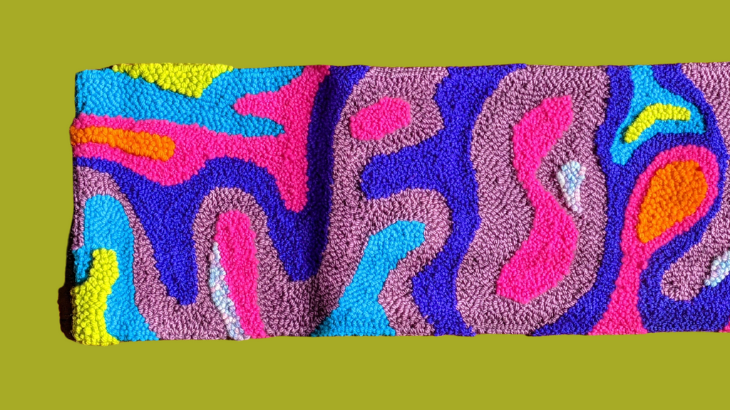This is an image of a psychedelic lava lamp-inspired rectangular punch needle rug featuring bold & neon colors. dancing arms punch needle embroidery, handmade in Los Angeles, California.