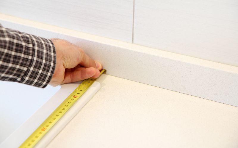 A man measuring the kitchen floor