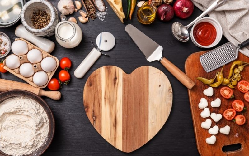 Heart shaped chopping board with ingredients on the side