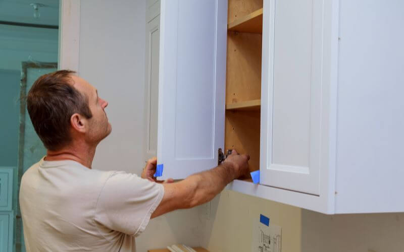 Man labeling cabinet doors