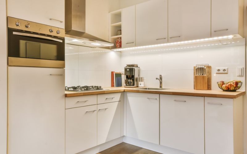 White kitchen with wooden worktop and gold accents