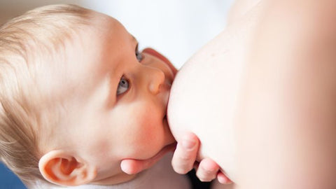 Mother breastfeeding baby in dancer-hand hold