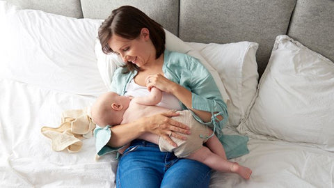 Mother breastfeeding baby in reclined breastfeeding position