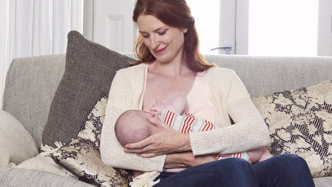 Mother breastfeeding baby in cross-cradle hold