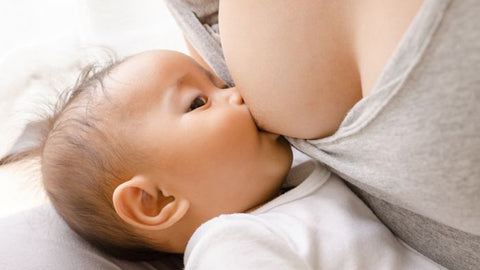 Mother breastfeeding baby in dangle feeding breastfeeding position