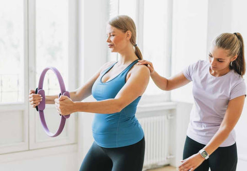Pregnant woman working out with prenatal fitness instructor.