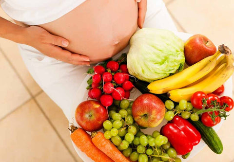 Pregnant woman with plate of fruits and vegetables