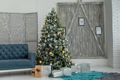 A green Christmas tree with gray gift boxes near the sofa.
