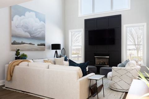 Large black fireplace as focal point with white couches and cloud art painting