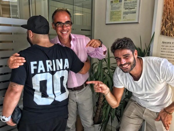 Mauro and Antimo Caputo pointing at a person wearing a Caputo jersey with their back towards the camer