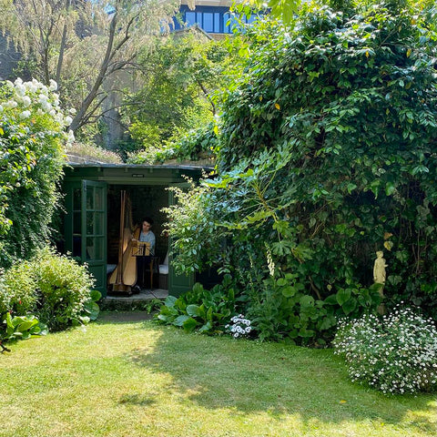 A harpist plays from inside the summerhouse of the Deanery