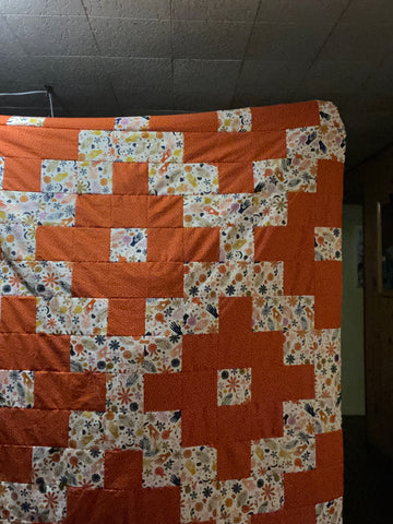 orange and light-colored graphic quilt top