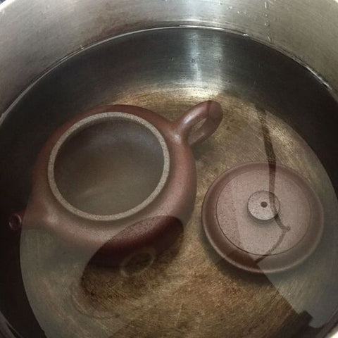 A wood fired dicaoqing teapot soaking in hot water. Don't boil your teapots!